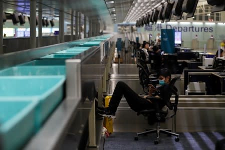 A demonstrator rests at the check-in counter in the departure hall after flights were cancelled during the anti-extradition bill protest at Hong Kong Airport