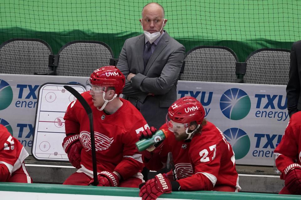 File-This April 20, 2021, file photo shows Detroit Red Wings head coach Jeff Blashill, rear, Adam Erne (73) and Michael Rasmussen (27) watching play against the Dallas Stars. The Red Wings are sticking with Blashill for their rebuild. General manager Steve Yzerman made the announcement Tuesday, May 18, 2021, giving Blashill a contract extension despite a five-year postseason drought and a career record of 172-221-62. (AP Photo/Tony Gutierrez, File)