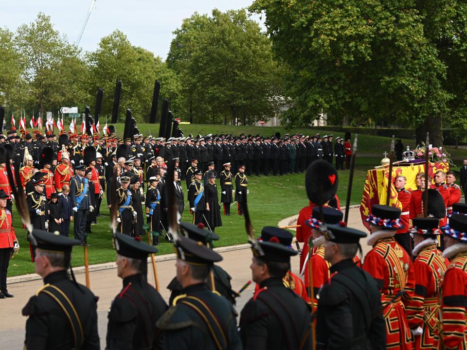 Members of the Royal Family including Prince William, Prince of Wales, Prince Harry, Duke of Sussex, King Charles III, Camilla, Queen Consort, Anne, Princess Royal, Prince Andrew, Duke of York, and Prince Edward, Earl of Wessex at Wellington Arch watching the coffin of Queen Elizabeth II being taken onto the State Hearse on September 19, 2022 in London, England.