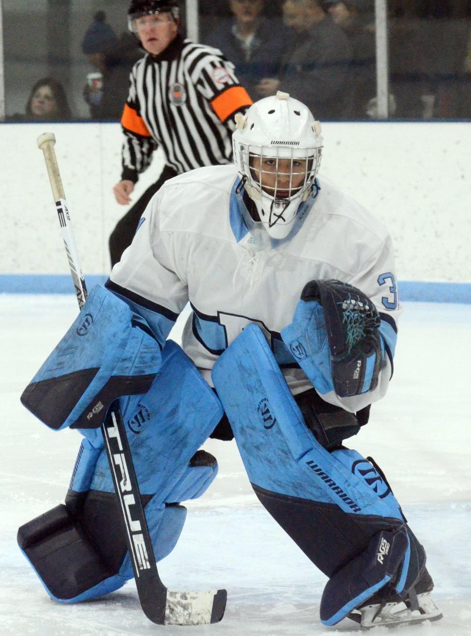 Petoskey goalie Joseph Wolfe watches play up against the boards during the second period.