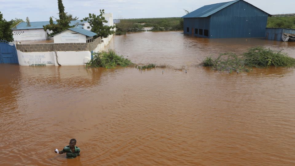 A man is seen in flood waters near a submerged church compound, after the River Tana broke its banks following heavy rains at Mororo, Kenya, on Sunday, April 28. - Andre Kasuku/AP