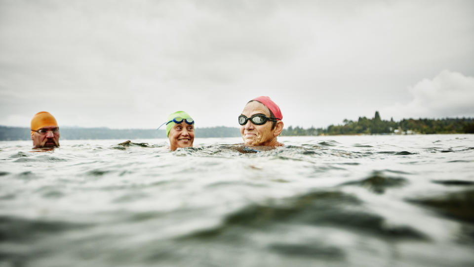 Smiling swimmers resting during open water swim