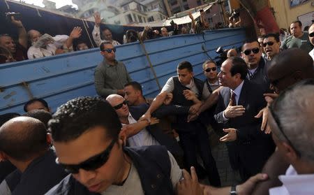 Presidential candidate and former army chief Abdel Fattah al-Sisi (R) gestures to his supporters as he arrives with his bodyguards at a polling station to cast his vote during the presidential election in Cairo May 26, 2014. REUTERS/Amr Abdallah Dalsh