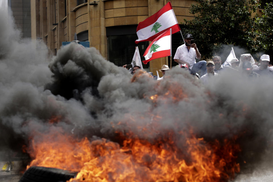 Lebanese retired soldiers burn tires as they protest in front of the government building during a cabinet meeting to discuss an austerity budget, in Beirut, Lebanon, Friday, May 10, 2019. Dozens of Lebanese military and security veterans burned tires and shouted angrily outside government offices on Friday, their second protest in less than two weeks amid fears a proposed austerity budget may affect their pensions and benefits. (AP Photo/Hassan Ammar)