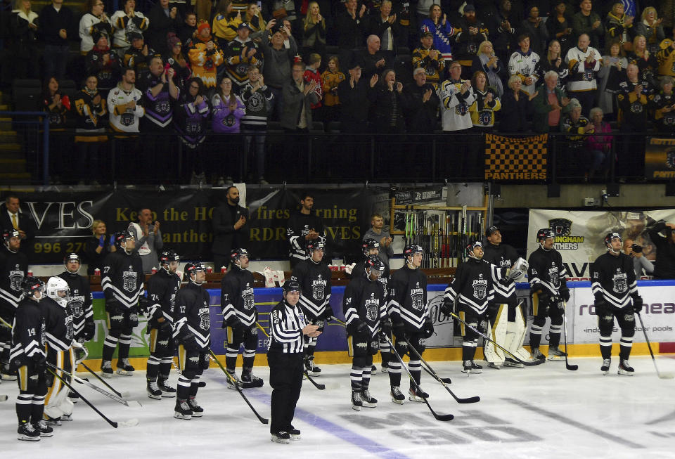 Nottingham Panthers players pay tribute during the Ice Hockey Adam Johnson memorial game between Nottingham Panthers and Manchester Storm at the Motorpoint Arena, Nottingham, England, Saturday, Nov. 18, 2023. "Import” hockey players in the United Kingdom don't earn big salaries but the lifestyle and perks are pretty good. They get free use of a car and rent-free housing. These mostly Canadian and American imports are mini-celebrities around the Elite Ice Hockey League. They can also earn a master's degree tuition-free. Adam Johnson of the Nottingham Panthers was living with his fiancée and studying at a business school. (AP Photo/Rui Vieira)