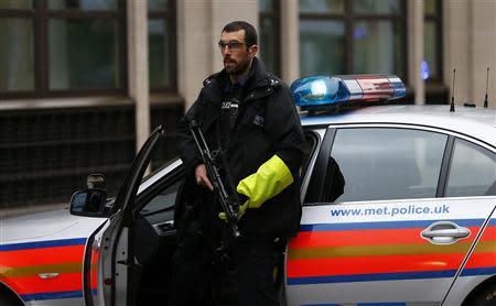 A police officer blocks the street while defendants under armed guard are driven into the Old Bailey in central London, December 3, 2013. REUTERS/Andrew Winning