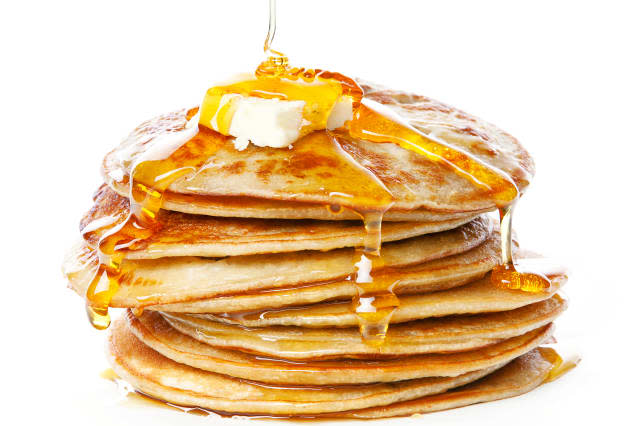 Stack of Small pancakes in syrup on white background