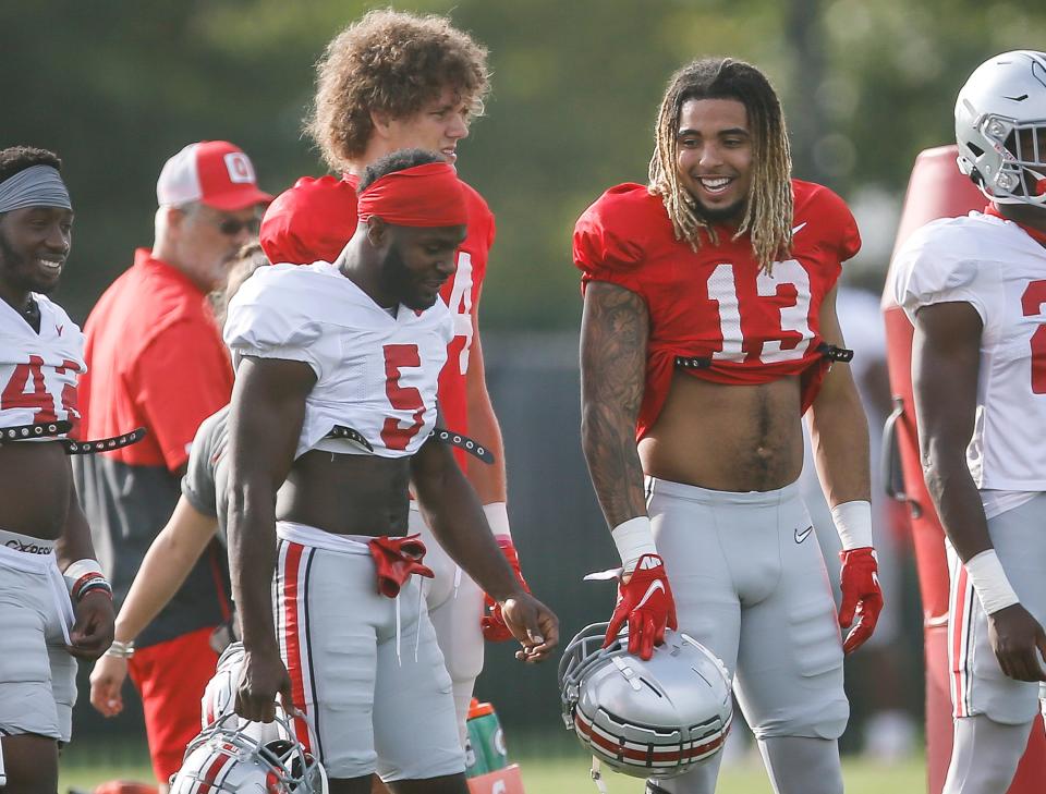 Ohio State Buckeyes tight end Gee Scott Jr. (13) talks to Ohio State Buckeyes cornerback Marcus Williamson (5) during football training camp at the Woody Hayes Athletic Center in Columbus on Tuesday, Aug. 10, 2021. 