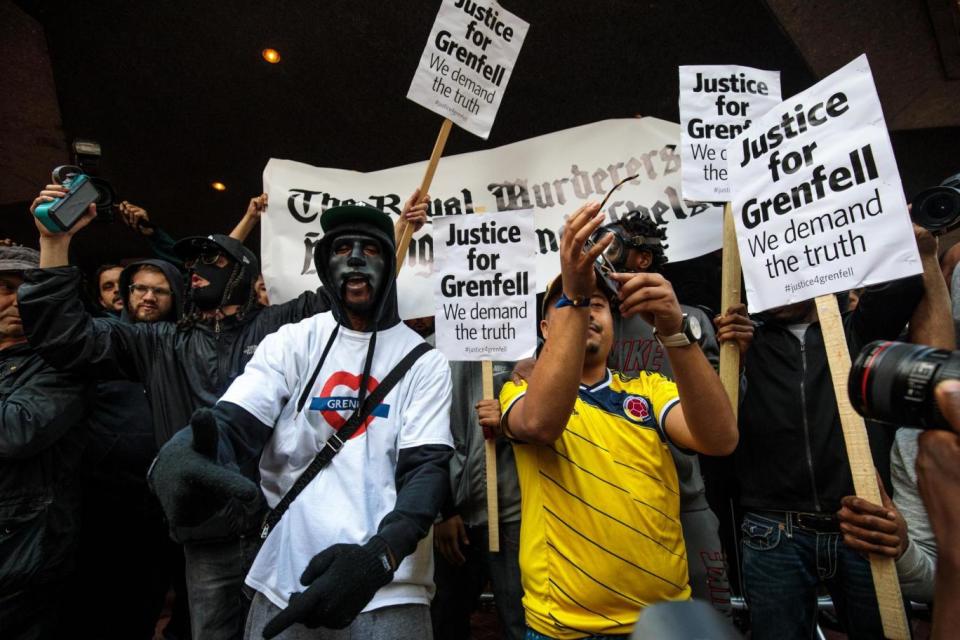 Campaigners wearing masks and holding placards. (Getty Images)