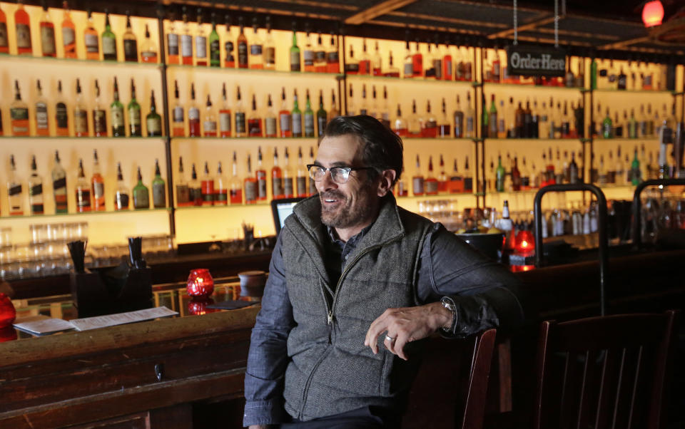 In this April 16, 2014 photo, actor Ty Burrell, who plays bumbling dad Phil Dunphy on ABC's “Modern Family,” sits at the bar at Bar X, the cocktail bar he co-owns, in Salt Lake City. Burrell just opened Beer Bar, a beer garden-like eatery next door to Bar X that serves 150 beers paired up with an array of house-made bratwursts, local breads and Belgian fries. The restaurant sports long tables and benches with high ceilings to evoke that Bavarian beer hall feel. (AP Photo/Rick Bowmer)