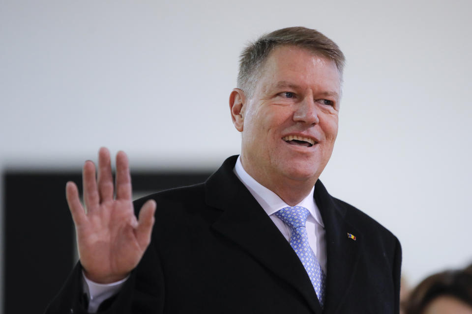 Romanian President Klaus Iohannis waves after casting his vote in Bucharest, Romania, Sunday, Nov. 24, 2019. Romanians are voting in a presidential runoff election in which incumbent Klaus Iohannis is vying for a second term, facing Social Democratic Party leader Viorica Dancila, a former prime minister, in Sunday's vote. (AP Photo/Vadim Ghirda)