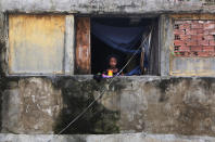 <p>Agatha, 13, stands in the window of her family’s home in the Mangueira favela, May 2, 2017, in Rio de Janeiro. (Photo: Mario Tama/Getty Images) </p>