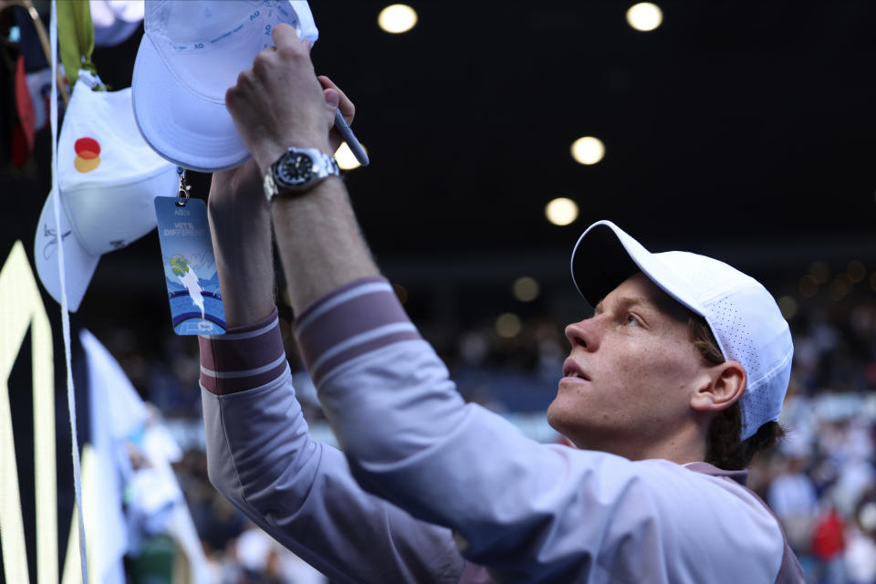 Jannik Sinner of Italy signs autographs after defeating Novak Djokovic of Serbia in their semifinal at the Australian Open tennis championships at Melbourne Park, Melbourne, Australia, Friday, Jan. 26, 2024. (AP Photo/Asanka Brendon Ratnayake)