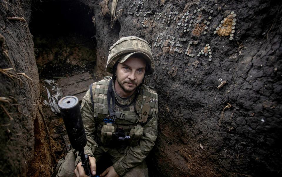 A Ukrainian serviceman looks on in a trench at a position near the frontline town of Bakhmut - STRINGER/REUTERS