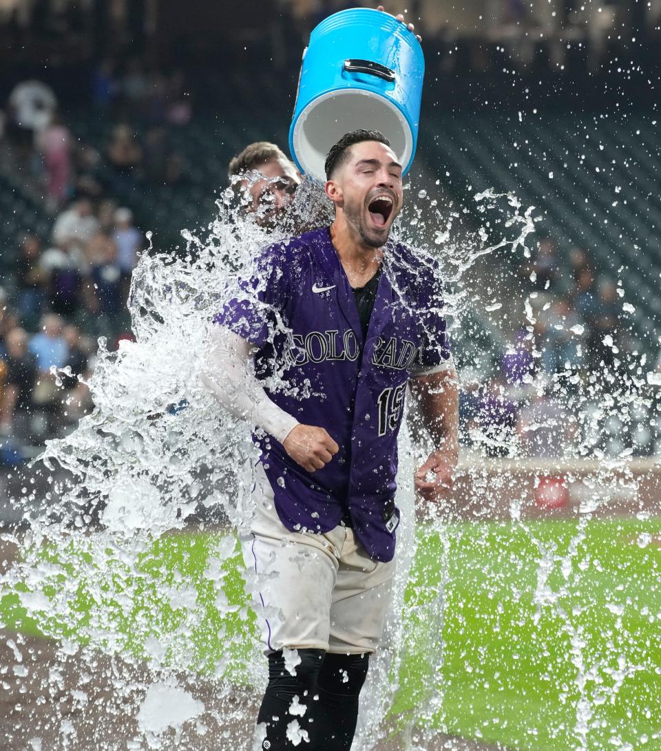 Rockies' Randall Grichuk gets a cold shower courtesy of teammate Charlie Blackmon after hitting a three-run home run against the Brewers in the 10th inning on Tuesday night.
