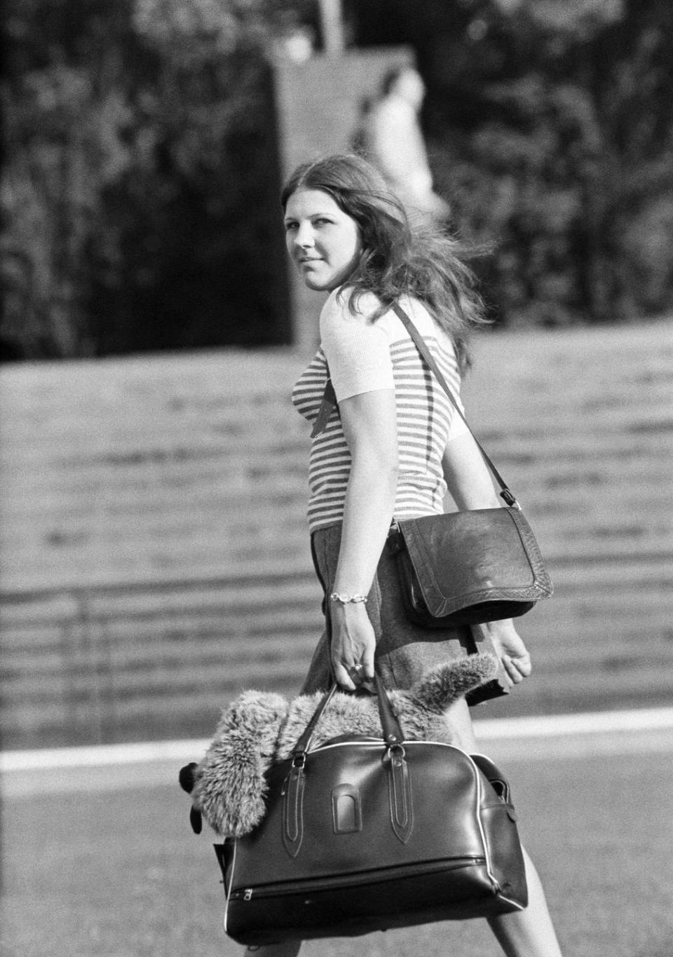 people, young girl with a handbag and a shopping bag look back to the camera, aged 18 to 22 years - 31.05.1973