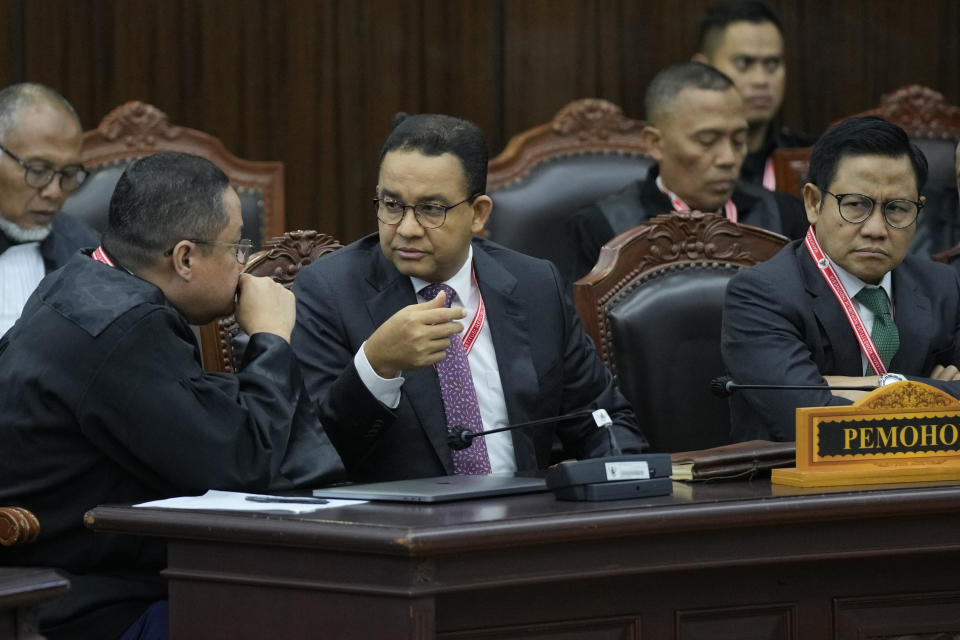 Presidential candidate Anies Baswedan, center, and his running mate Muhaimin Iskandar, right, confer with their lawyer Ari yusuf Amir during their election appeal hearing at the Constitutional Court in Jakarta, Indonesia, Monday, April 22, 2024. The country's top court on Monday rejected appeals lodged by two losing presidential candidates who are demanding a revote, alleging widespread irregularities and fraud at the February polls. (AP Photo/Dita Alangkara)