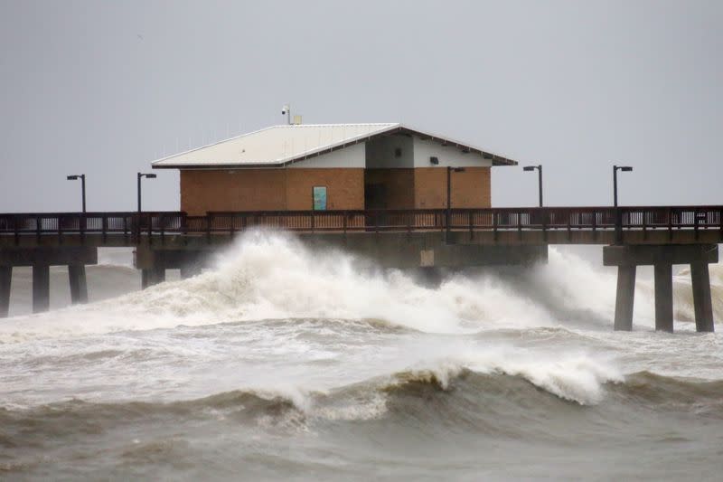 Waves crash along a pier as Hurricane Sally approaches in Gulf Shores