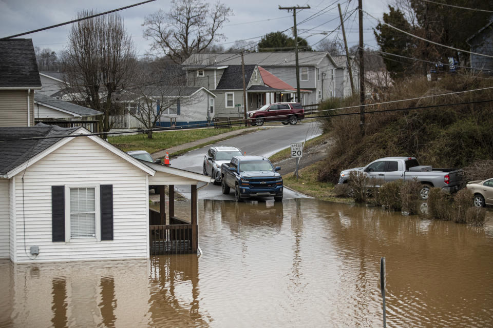 Flood water enters homes at the intersection of McGhee and Mason Street on Friday, Feb. 17, 2023, in Milton, W.Va. The flooding came amid a string of thunderstorms that inundated the South and dumped nearly 3 inches (8 centimeters) of rain in parts of West Virginia. (Sholten Singer/The Herald-Dispatch via AP)