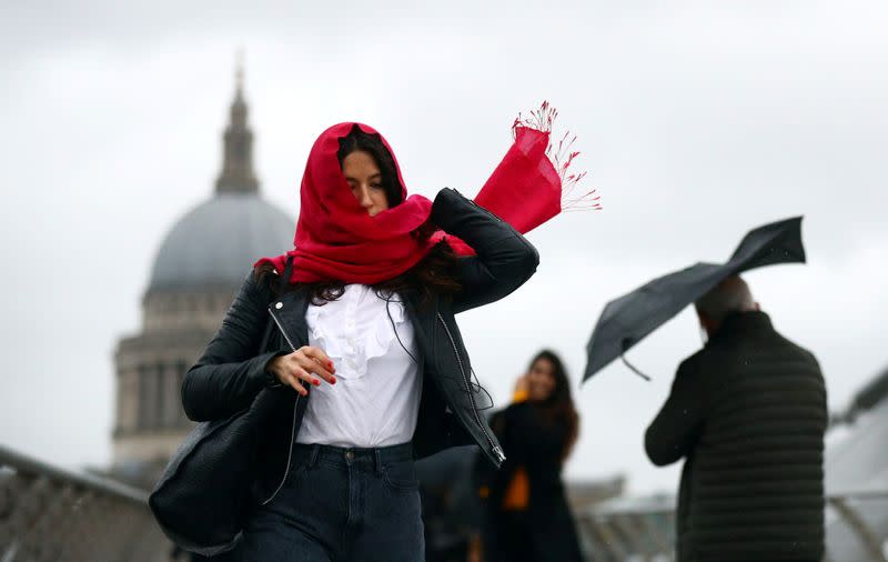 People walk in windy conditions across Millennium Bridge during storm Dennis in London