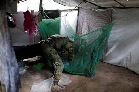 A specialised inspector searches a miners' camp at an illegal gold mine during an operation conducted by agents of the Brazilian Institute for the Environment and Renewable Natural Resources, or Ibama, in national parks near Novo Progresso, southeast of Para state, Brazil, November 5, 2018. REUTERS/Ricardo Moraes