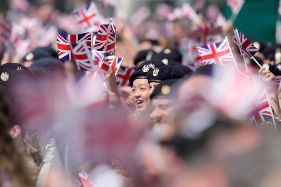 People in uniform wave flags