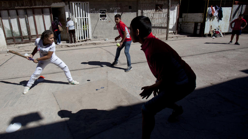 Caacupe cricket team Milagros Mendez, left, bats during a training session at the Villa 21-24 slum in Buenos Aires, Argentina, Saturday, March 22, 2014. The International Cricket Council has recognized the team, formed from the children of the Villa 21-24 shantytown, honoring them as a global example for expanding the sport, which in certain countries, like India, is widely played, but in many parts of the world restricted to elite sectors of society. Introducing cricket in the slum began in 2009 as an idea to transform the game into a social integration mechanism, before that it rarely breached the gates of the country's upscale private schools. (AP Photo/Natacha Pisarenko)