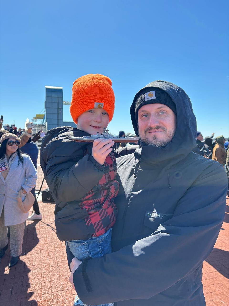 Holden (left) and Derek Weikel (right) watch the Battleship New Jersey depart Camden.