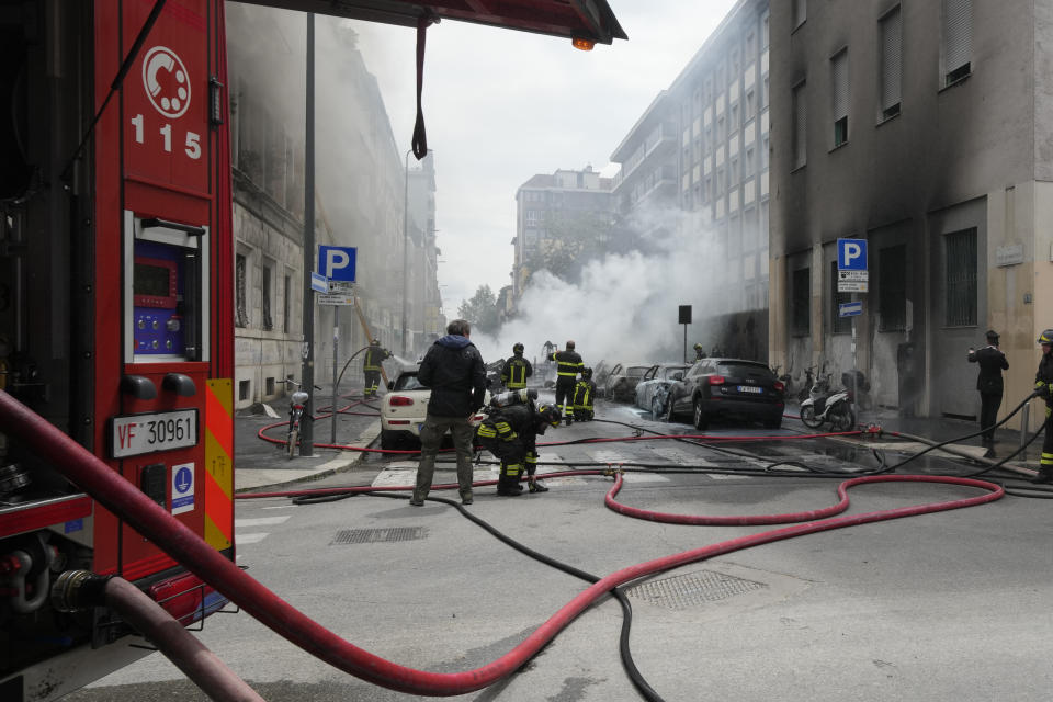 Firefighters work to extinguish a fire in a building after a van exploded in central Milan, northern Italy, Thursday, May 11, 2023. (AP Photo/Luca Bruno)