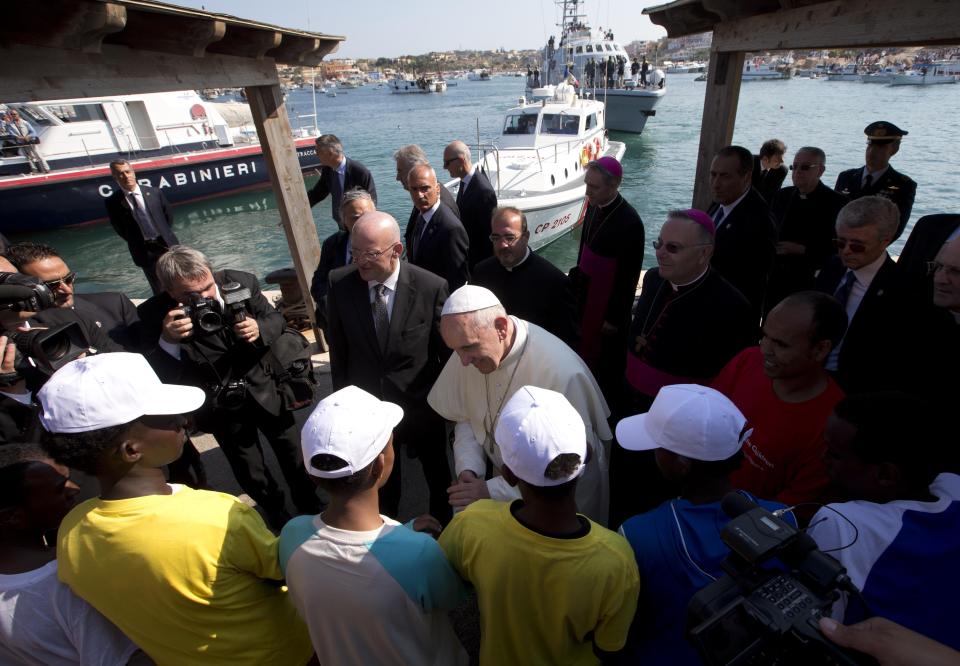 Pope Francis speaks to migrants, wearing white caps, during his visit to the island of Lampedusa, southern Italy, Monday July 8, 2013. Ten years after Pope Francis made a landmark visit to the Italian island of Lampedusa to show solidarity with migrants, he is joining Catholic bishops from around the Mediterranean this weekend in France to make the call more united, precisely at the moment that European leaders are again scrambling to stem the tide of would-be refugees setting off from Africa. (AP Photo/Alessandra Tarantino, File)