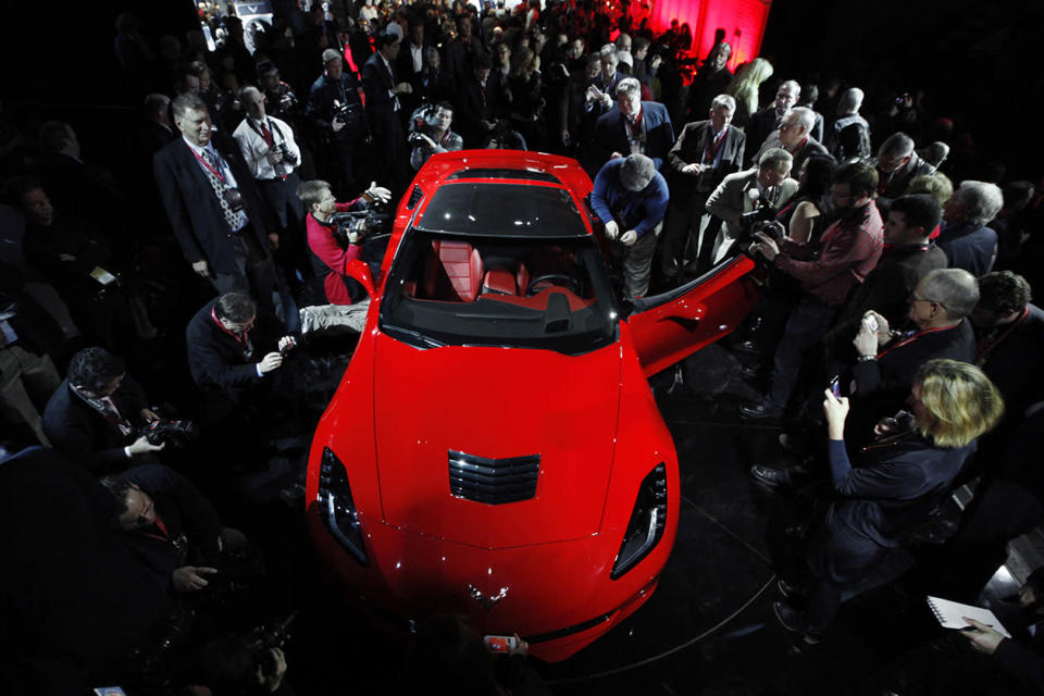 Journalists surround General Motors new 2014 Chevrolet Corvette Stingray.