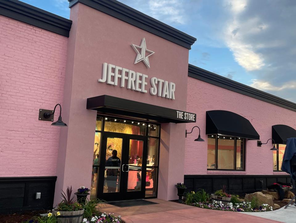 pink Jeffree Star store with black awnings and concrete path leading into it