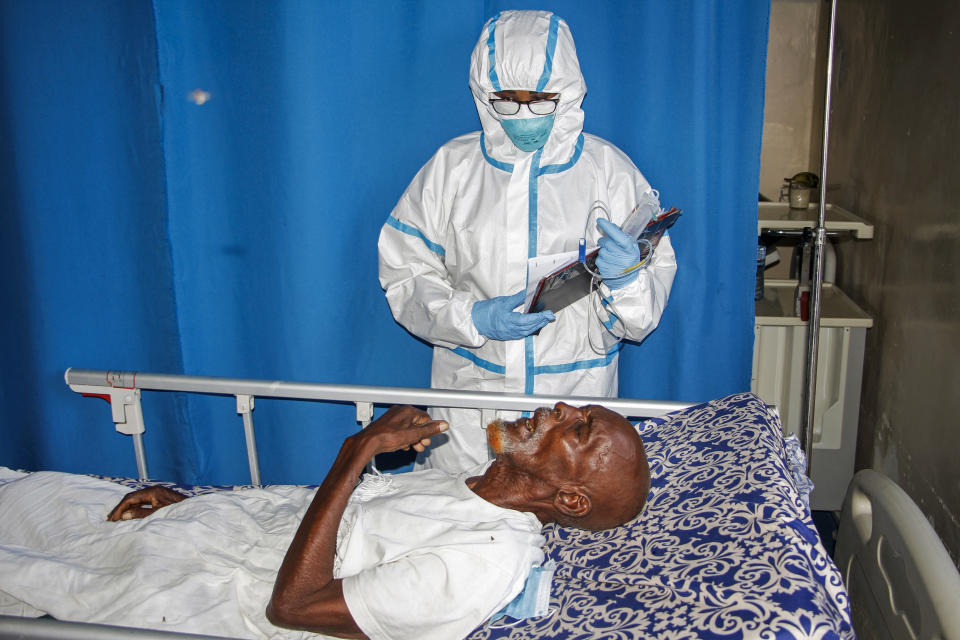 In this photo taken Wednesday, May, 13, 2020, a doctor tends to a patient in a ward for coronavirus patients at the Martini Hospital in Mogadishu, Somalia. Years of conflict, instability and poverty have left Somalia ill-equipped to handle a health crisis like the coronavirus pandemic. (AP Photo/Farah Abdi Warsameh)
