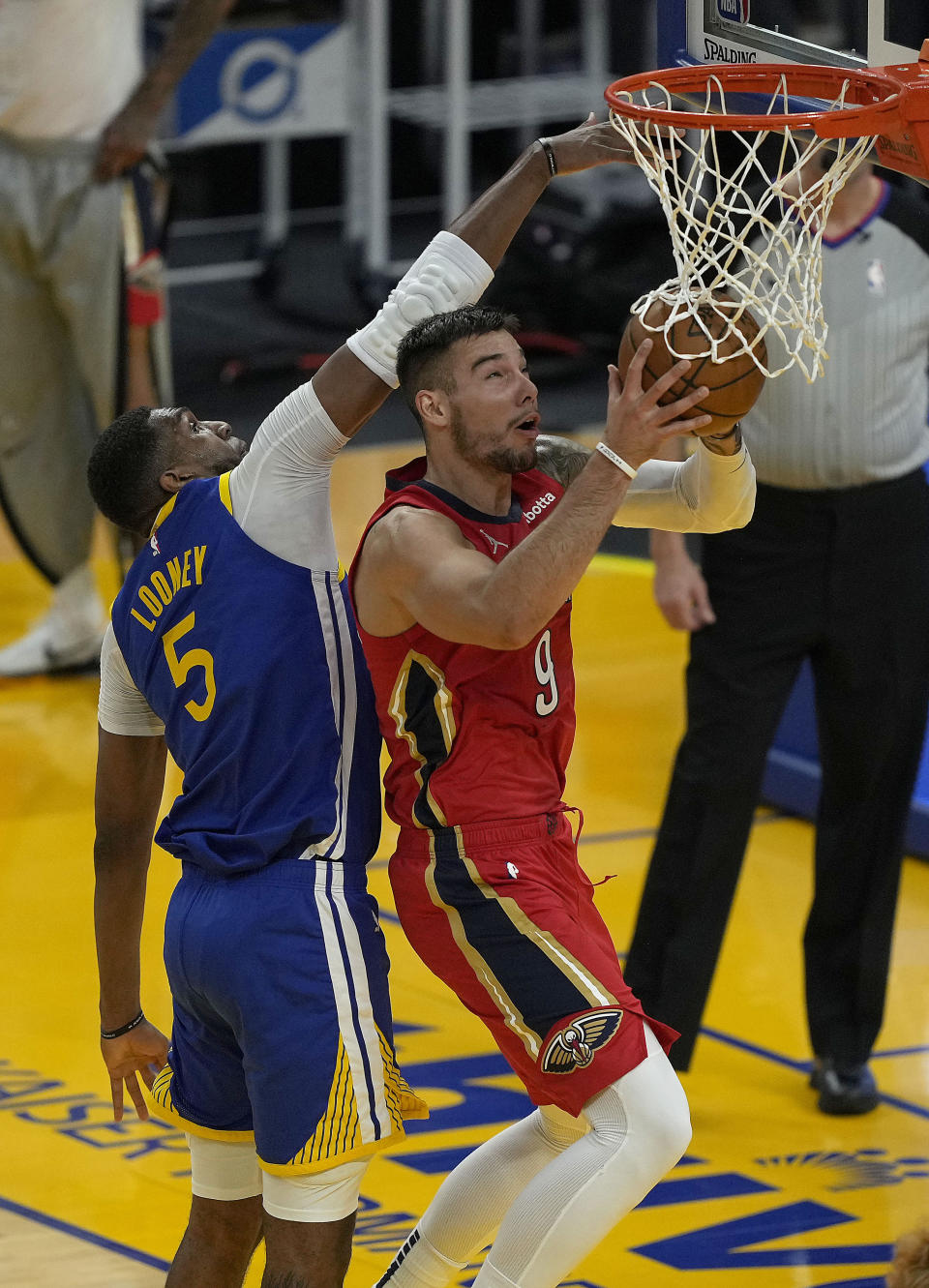 New Orleans Pelicans center Willy Hernangomez (9) drives to the basket against Golden State Warriors center Kevon Looney (5) during the first half of an NBA basketball game on Friday, May 14, 2021, in San Francisco. (AP Photo/Tony Avelar)