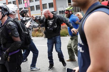 A demonstrator against U.S. President Donald Trump (C) fights with a group of conservative demonstrators during a Patriots Day Free Speech Rally in Berkeley, California, U.S., April 15, 2017. REUTERS/Stephen Lam