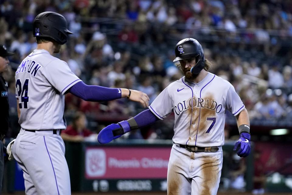 Colorado Rockies' Brendan Rodgers (7) and Ryan McMahon (24) celebrate their runs scored against the Arizona Diamondbacks during the sixth inning of a baseball game Sunday, Aug. 7, 2022, in Phoenix. (AP Photo/Ross D. Franklin)