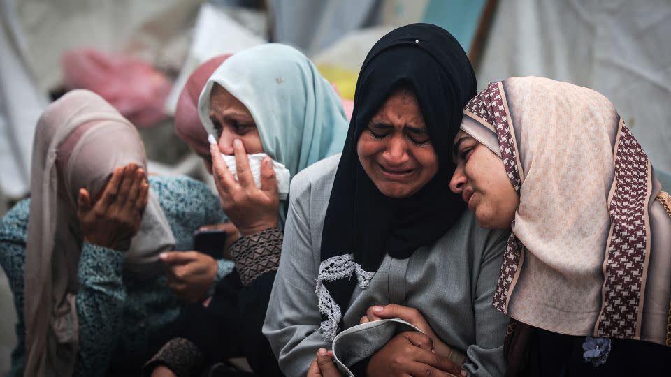 Palestinians mourn their relatives, killed in an overnight Israeli strike on the Al-Maghazi refugee camp, during a mass funeral at the Al-Aqsa hospital in Gaza on December 25, 2023. - Mahmud Hams/AFP/Getty Images