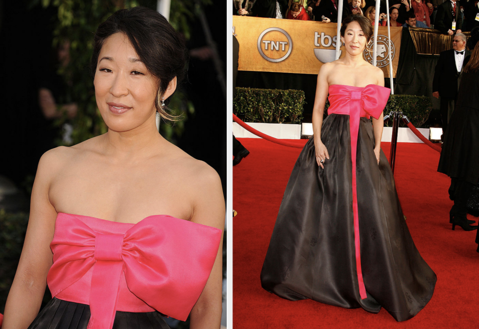 Sandra Oh on red carpet in a strapless gown with oversized pink bow and black skirt