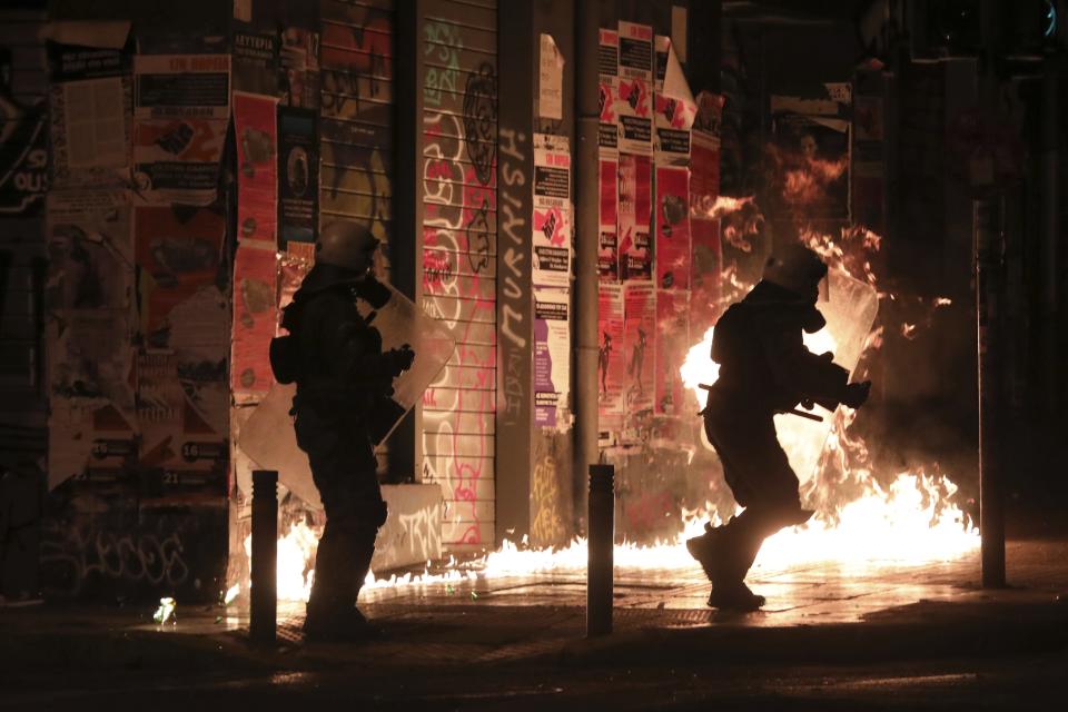 Riot policemen try to avoid a petrol bomb during clashes in the Athens neighborhood of Exarchia, a haven for extreme leftists and anarchists, Saturday, Nov. 17, 2018. Several thousands people marched to the U.S. Embassy in Athens under tight police security to commemorate a 1973 student uprising that was crushed by Greece's military junta, that ruled the country from 1967-74. (AP Photo/Yorgos Karahalis)