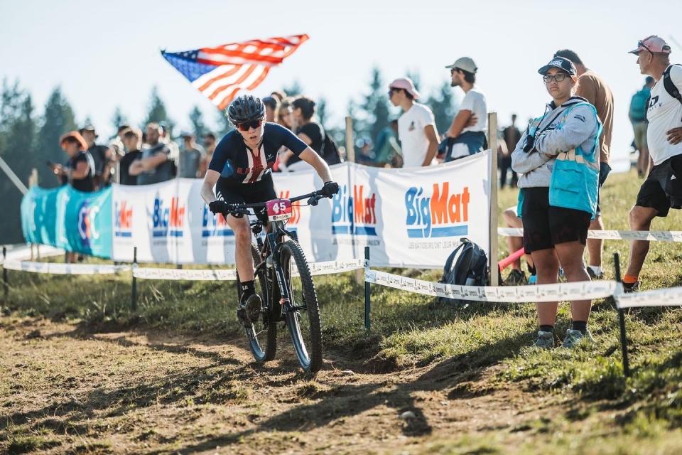 Lauren Lackman passes an American flag while competing in the UCI Mountain Bike World Championships in Les Gets, France.