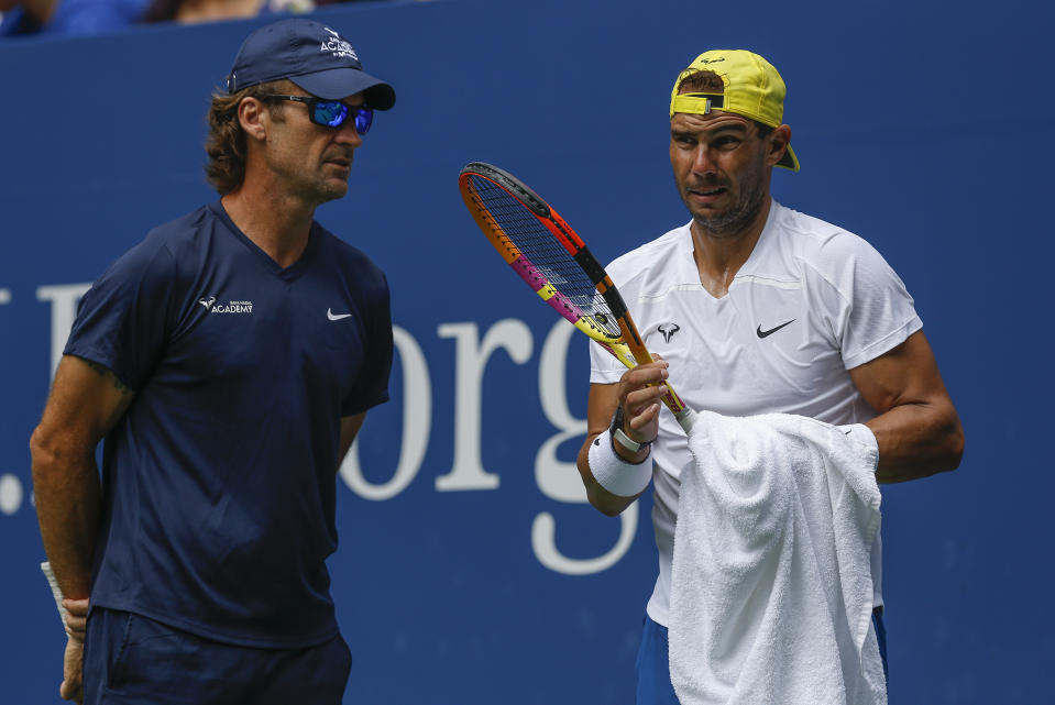 Rafael Nadal charla con su entrenador Carlos Moyá durante una práctica previo al US Open, el viernes 26 de agosto de 2022. (AP Foto/Julie Jacobson)