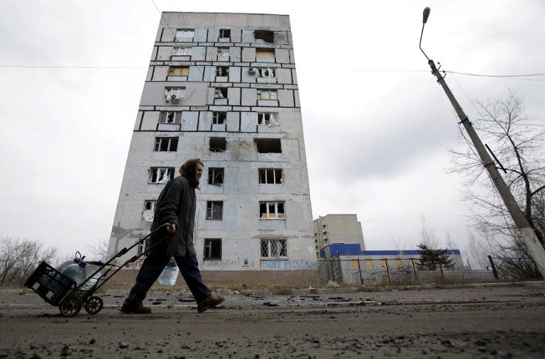 A Ukrainian resident hauls a trolly loaded with water containers along a street in Avdiivka, on March 2, 2015