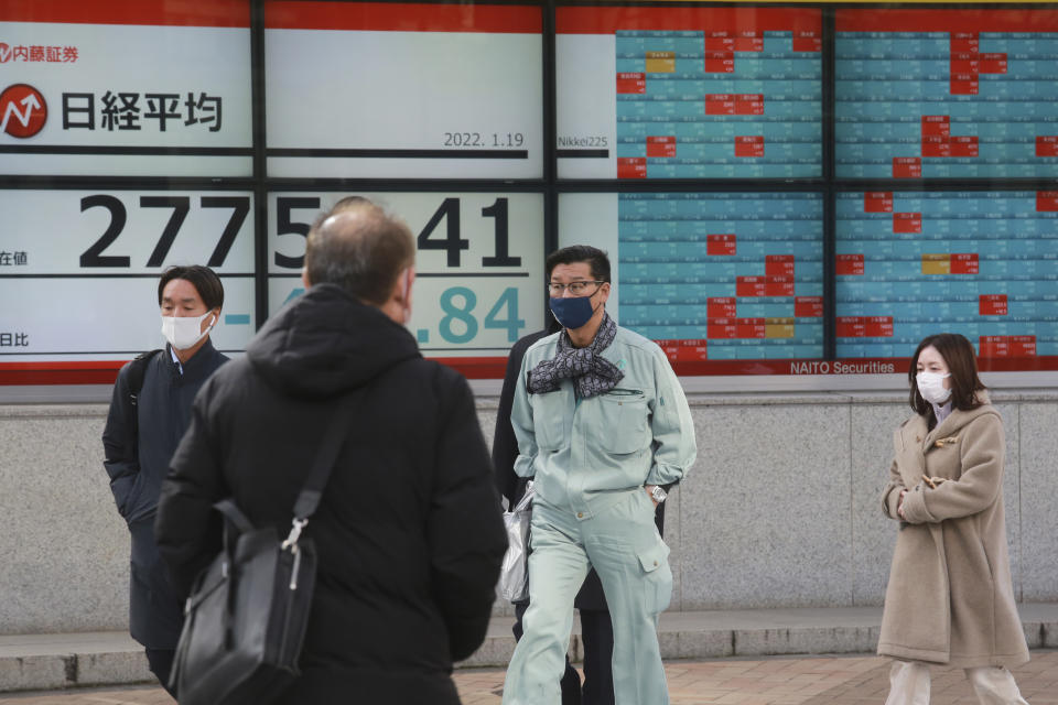 People walk by an electronic stock board of a securities firm in Tokyo, Wednesday, Jan. 19, 2022. Asian shares were lower Wednesday after a retreat on Wall Street. (AP Photo/Koji Sasahara)