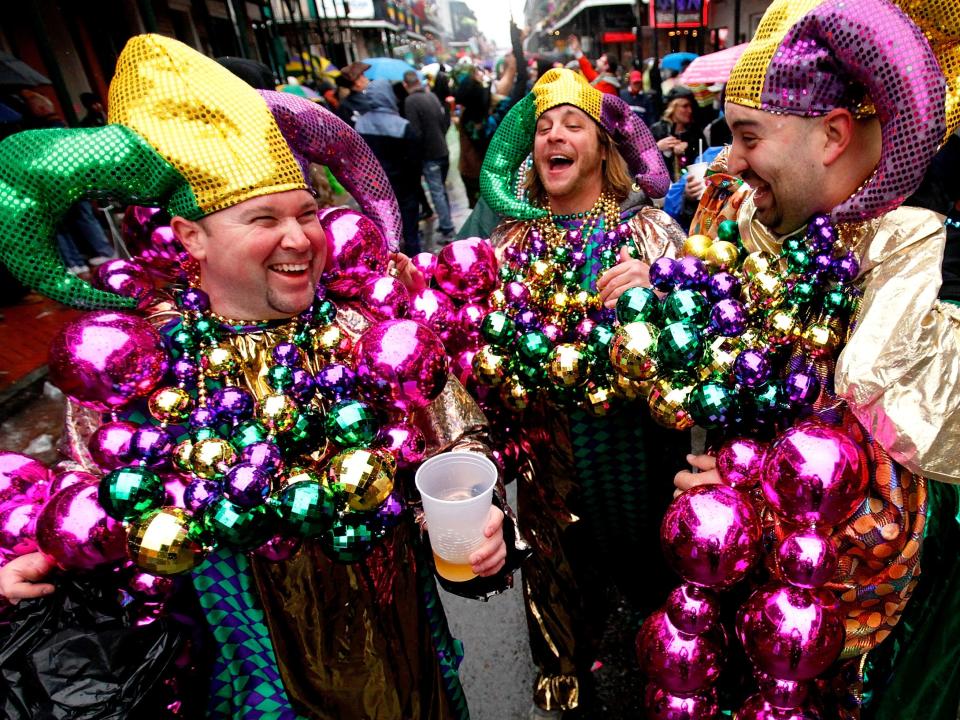 people wearing beads and hats celebrating mardi gras