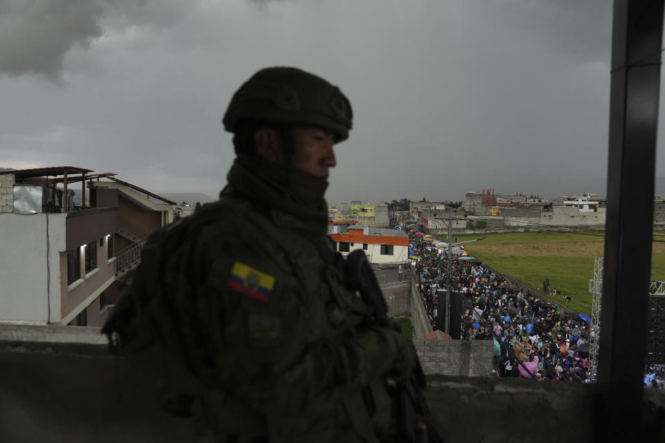 A soldier guards as supporters of presidential candidate Luisa Gonzalez, of the Citizen's Revolutionary Movement, attend a campaign rally in Quito, Ecuador, Wednesday, Oct. 11, 2023. (AP Photo/Dolores Ochoa)