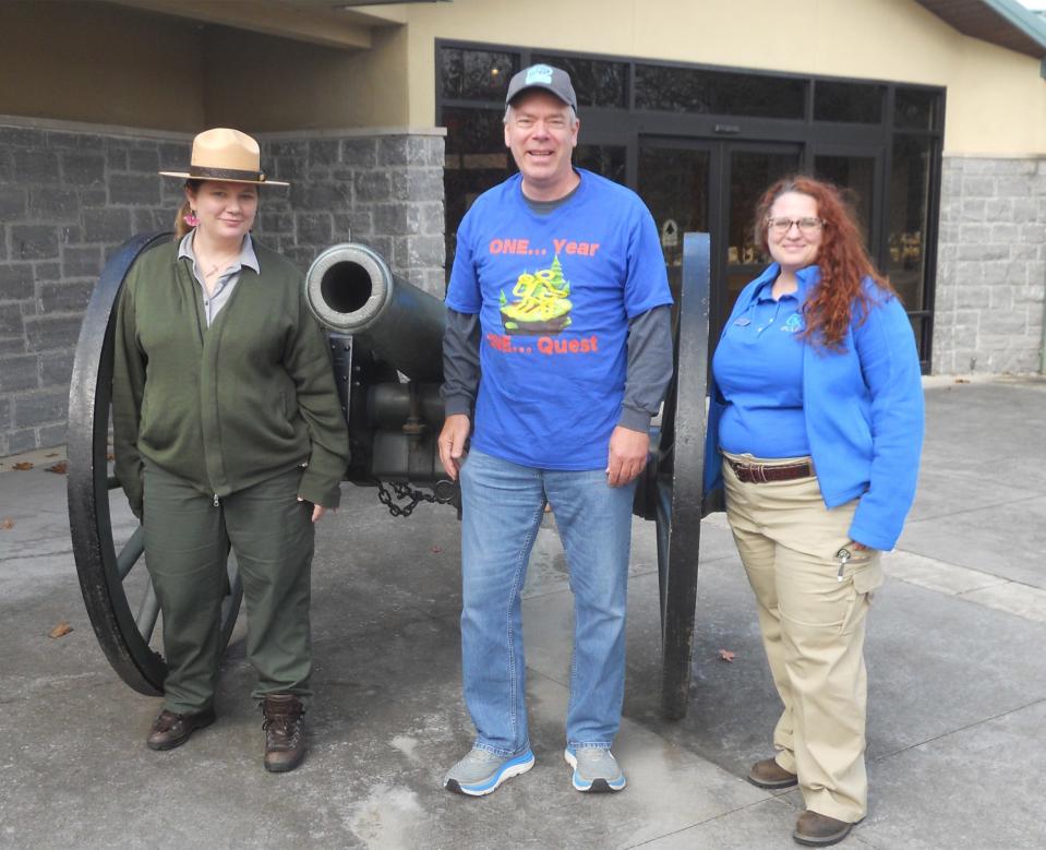 Thomas Wright, who visited every U.S. national park this year, poses next to a Civil War cannon with a ranger and volunteer at Stones River National Battlefield in Tennessee.
