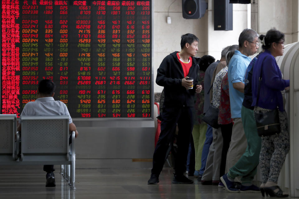 In this Thursday, Sept. 19, 2019, photo, Chinese investors check stock prices at a brokerage house in Beijing. Asian shares were mostly higher on Friday, Sept. 20, 2019 after a lackluster session on Wall Street, as investors shifted their focus to China-U.S. trade talks after a busy week of central bank news. (AP Photo/Andy Wong)