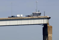 People work on a standing section of the collapsed Francis Scott Key Bridge, Monday, April 15, 2024, in Baltimore. The FBI confirmed that agents were aboard the Dali conducting court-authorized law enforcement activity. (AP Photo/Julia Nikhinson)