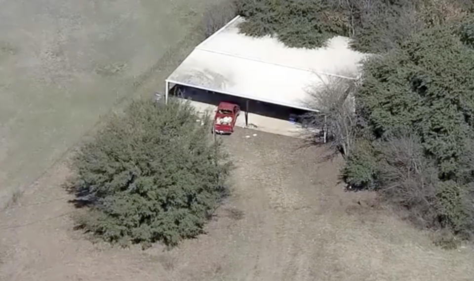 This aerial image provided by KDFW-FOX4 News shows part of the property where deputies found two young, malnourished children locked together in a dog cage near Rhome, Texas about 20 miles (32 kilometers) northwest of Fort Worth. A Texas sheriff says, Tuesday, Feb. 12, 2019, deputies responding to a domestic disturbance at a home discovered two young, malnourished children locked together in a dog cage while two others also were found malnourished.