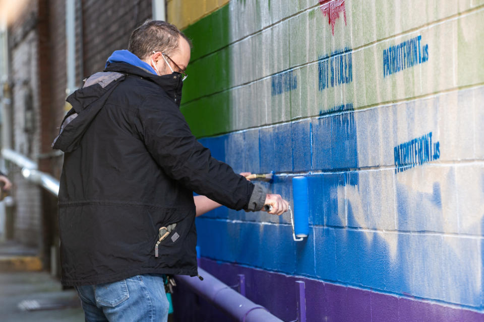 A volunteer repaints a pride mural on the side of a business in Bellefonte, Penn. on Jan. 9, 2021. The mural was defaced with graffiti from the white supremacist group Patriot Front, which was behind the majority of white supremacist propaganda in the U.S. last year, according to a new report by the Anti-Defamation League. (Paul Weaver/SOPA Images/LightRocket via Getty Images)